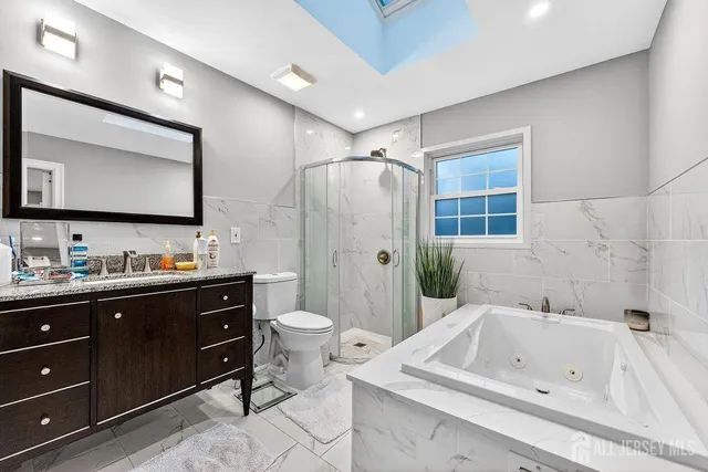 a bathroom with a tub sink toilet mirror and vanity