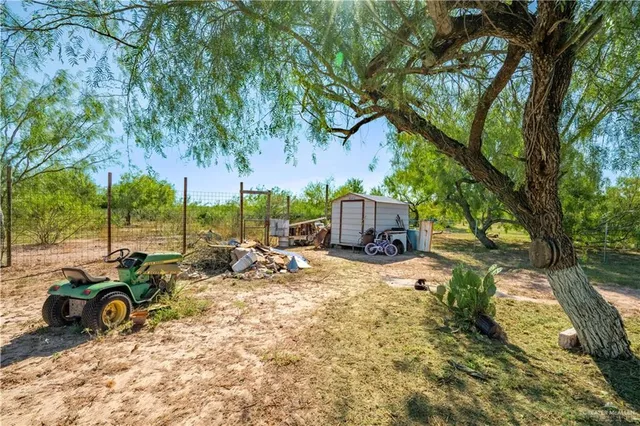 a view of a backyard with table and chairs and a large tree