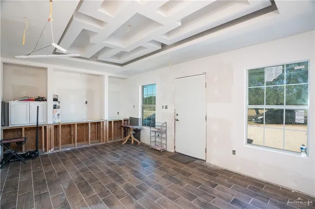 a view of an empty room with furniture and a window