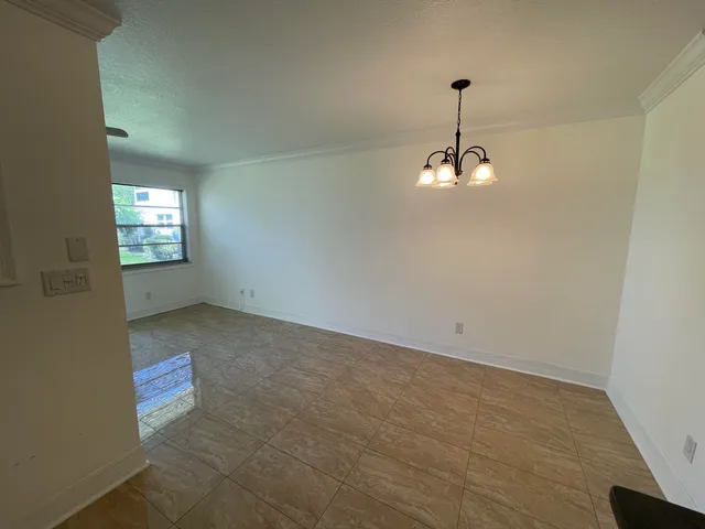 a view of empty room with a kitchen