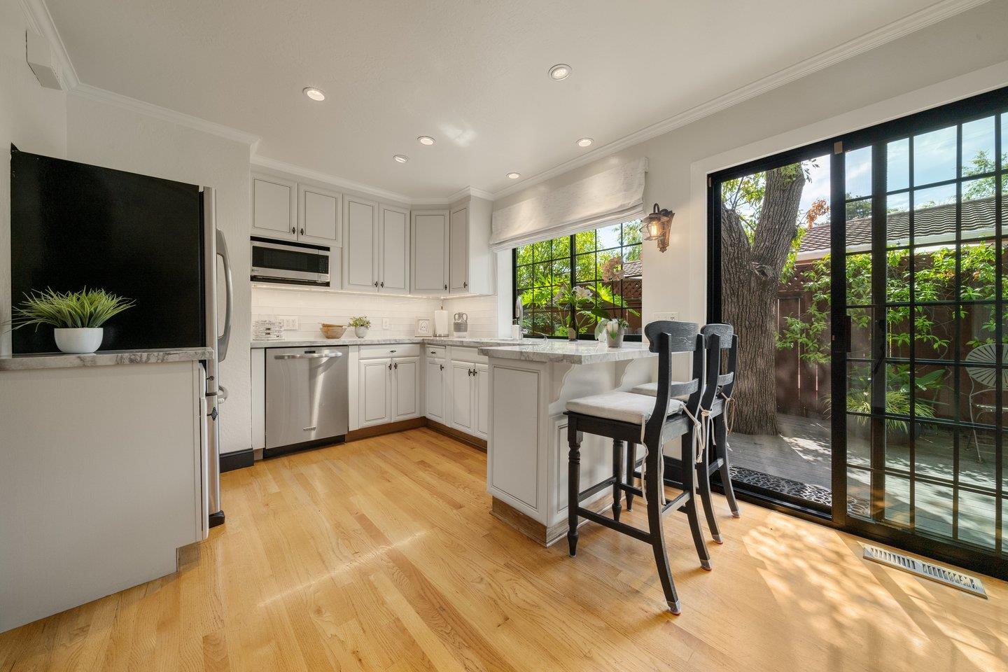 680 Cambrian Drive Campbell, CA 95008 - Photo 17 of 62 a kitchen with stainless steel appliances granite countertop a stove top oven a sink a dining table and chairs with wooden floor