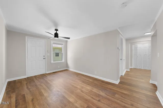 a view of an empty room with wooden floor