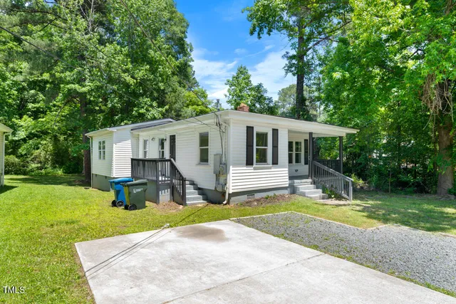 a view of a house with a yard and sitting area