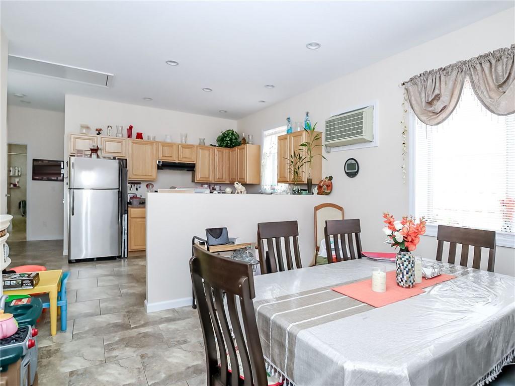 480 Van Sicklen Street Brooklyn, NY 11223 - Photo 21 of 31 a dining room with furniture a large window and stainless steel appliances