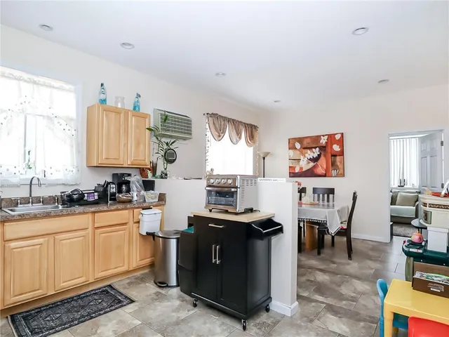 a kitchen with stainless steel appliances granite countertop a stove top oven a sink dishwasher and cabinets with wooden floor