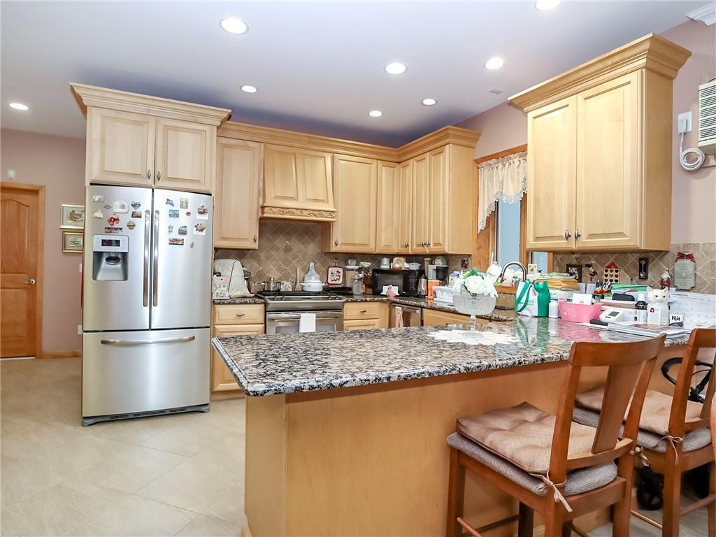 480 Van Sicklen Street Brooklyn, NY 11223 - Photo 7 of 31 a kitchen with stainless steel appliances granite countertop a refrigerator a stove a sink a dining table and chairs