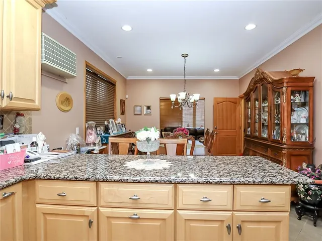 a kitchen with granite countertop kitchen island stainless steel appliances a sink stove and cabinets