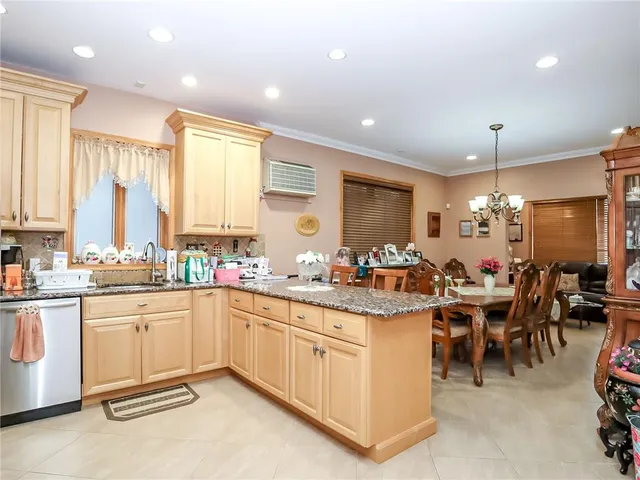 a large kitchen with lots of white cabinets a sink dishwasher a dining table and chairs
