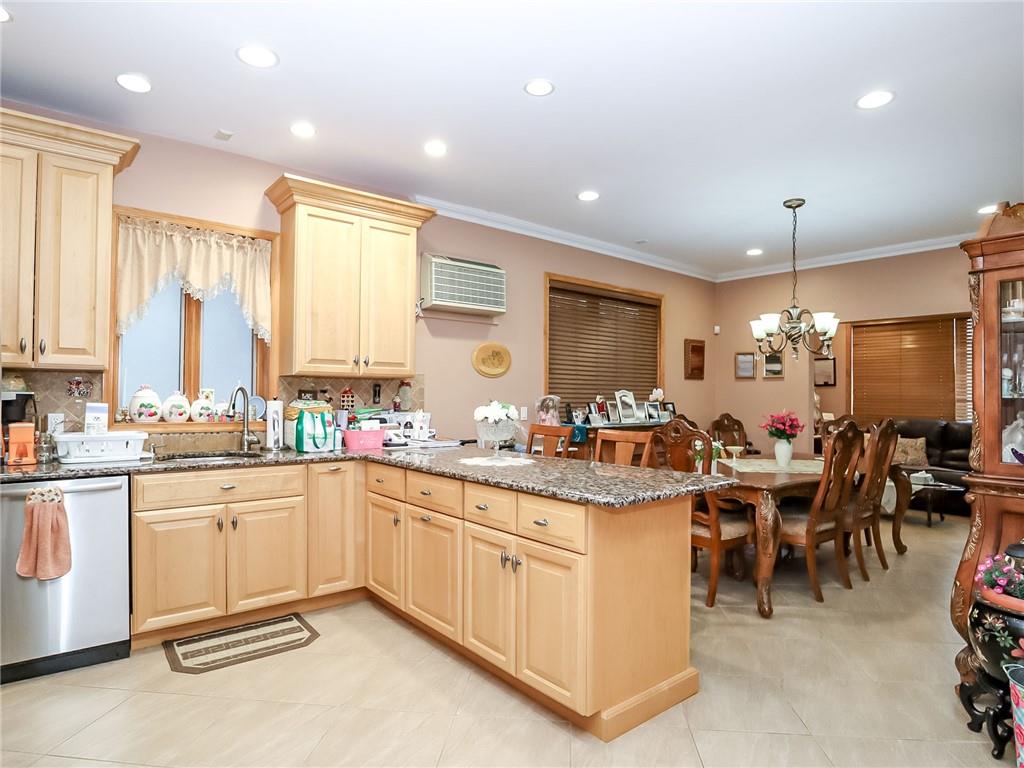 480 Van Sicklen Street Brooklyn, NY 11223 - Photo 10 of 31 a large kitchen with lots of white cabinets a sink dishwasher a dining table and chairs