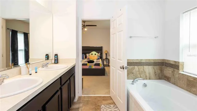 a en suite bathroom with a tub sink and mirror
