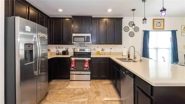 a kitchen with kitchen island granite countertop stainless steel appliances cabinets a sink and a counter top space