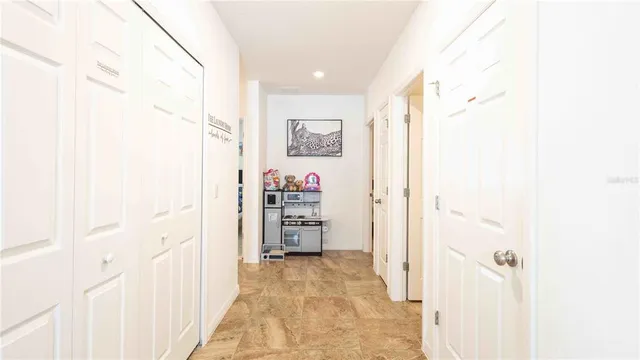 a view of a hallway with closet and bathroom