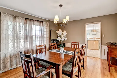 a dining room with furniture a chandelier and wooden floor