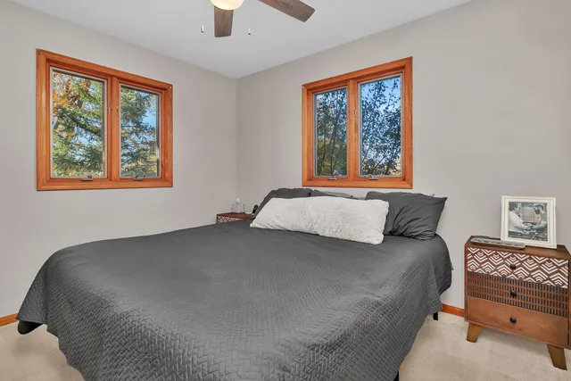 a bedroom with a bed a painting on the wall and a window
