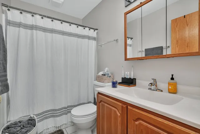 a bathroom with a sink a toilet and shower curtain