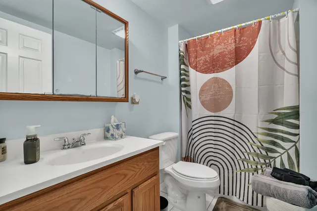 a bathroom with a sink a toilet and a mirror