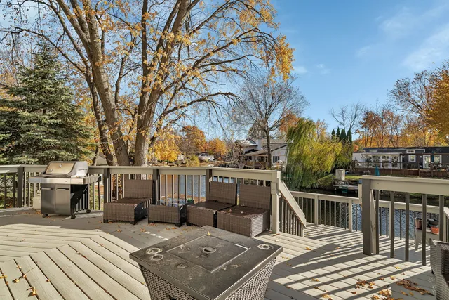 a view of a patio with table and chairs with wooden floor and fence