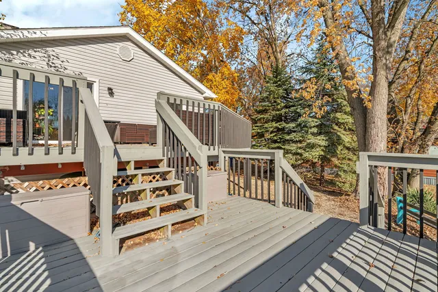 a view of a house with wooden deck and furniture