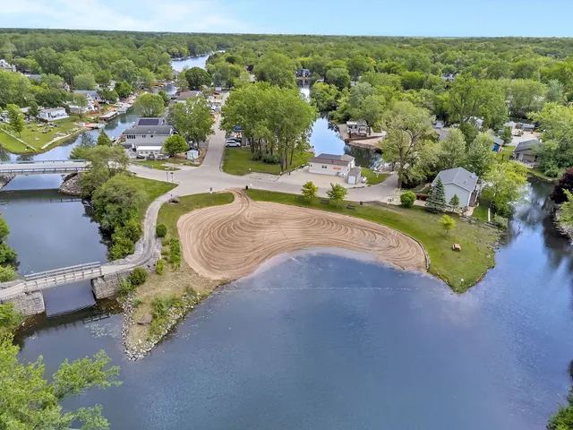 an aerial view of a house with a garden and lake view
