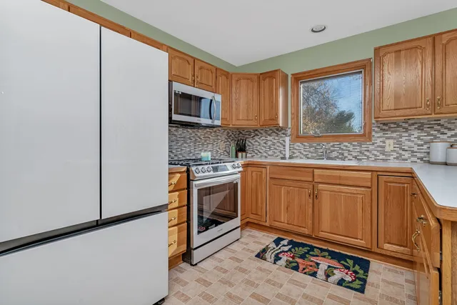 a kitchen with stainless steel appliances granite countertop a stove a sink and a refrigerator