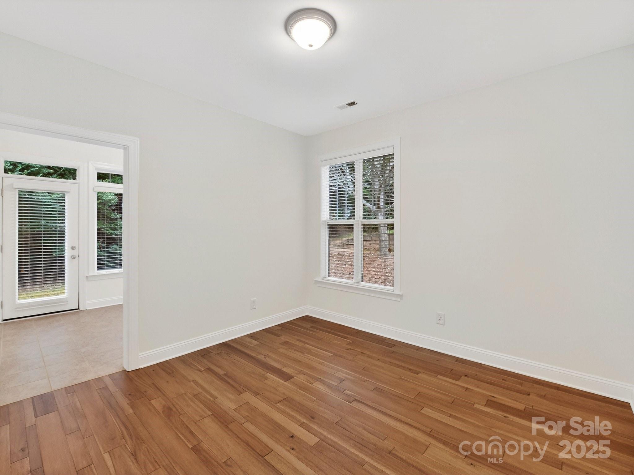 2963 Bellasera Way Matthews, NC 28105 - Photo 20 of 46 an empty room with wooden floor and windows