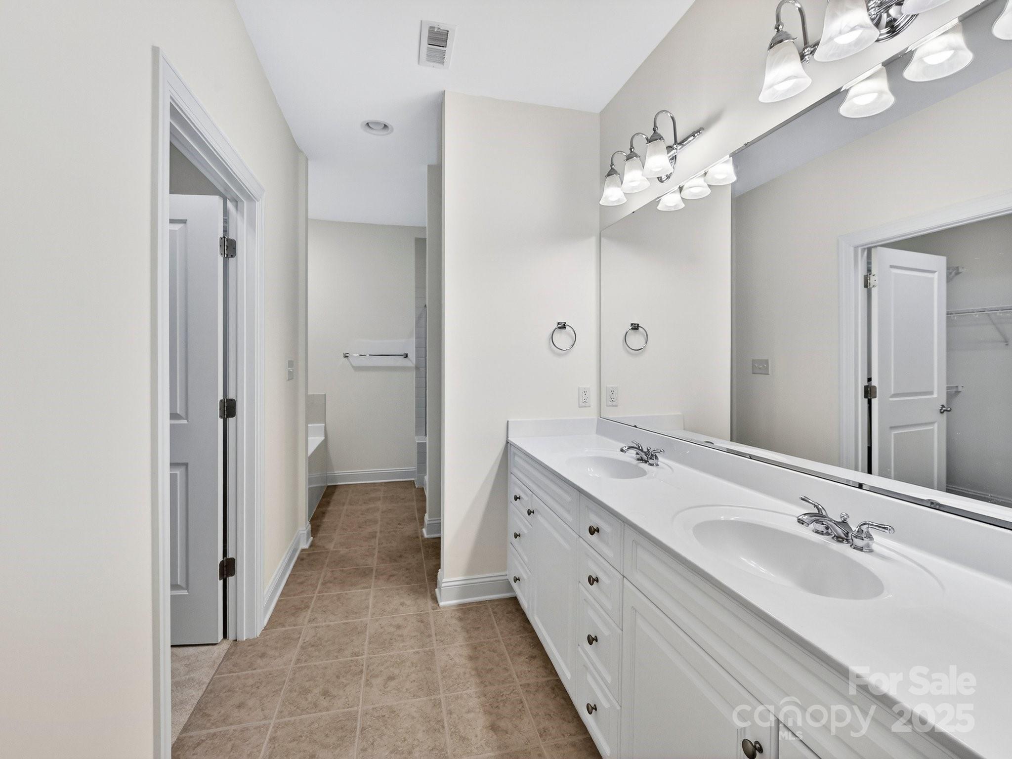 2963 Bellasera Way Matthews, NC 28105 - Photo 25 of 46 a spacious bathroom with a double vanity sink a mirror and a shower