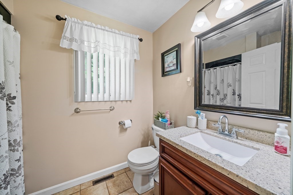 28 Gammons Road Acushnet, MA 02743 - Photo 21 of 39 a bathroom with a granite countertop toilet sink and mirror