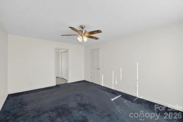 an empty room with a ceiling fan and a window