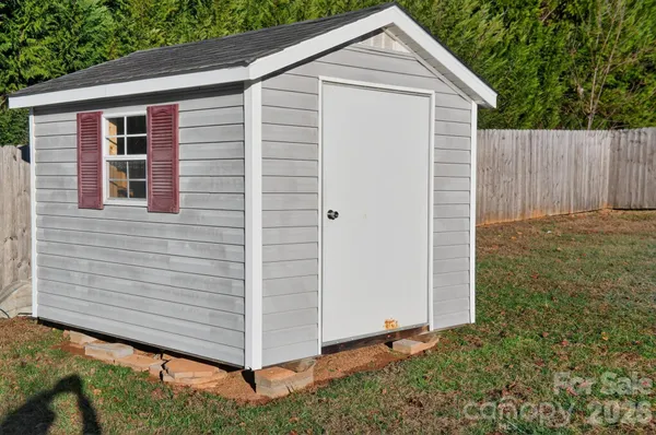 a view of backyard with small cabin