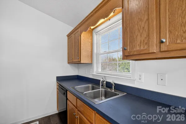 a kitchen with granite countertop a sink and a white cabinets