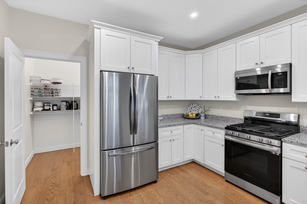 10 Logans Run, Unit 10 Millbury, MA 01527 - Photo 16 of 42 a kitchen with stainless steel appliances a refrigerator stove and microwave