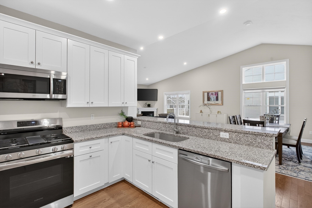10 Logans Run, Unit 10 Millbury, MA 01527 - Photo 19 of 42 a kitchen with granite countertop a sink and a stove top oven