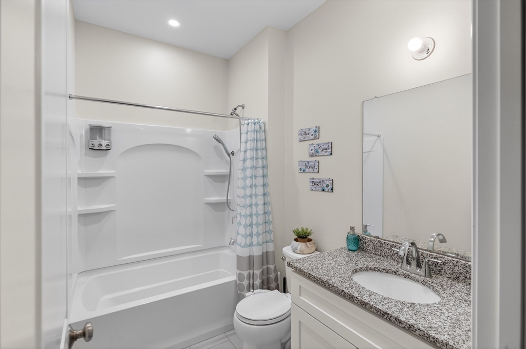 10 Logans Run, Unit 10 Millbury, MA 01527 - Photo 29 of 42 a bathroom with a granite countertop sink toilet mirror and shower