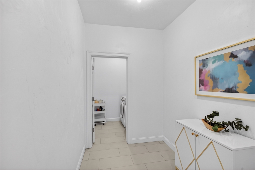10 Logans Run, Unit 10 Millbury, MA 01527 - Photo 6 of 42 a room with a wall painting and a potted plant
