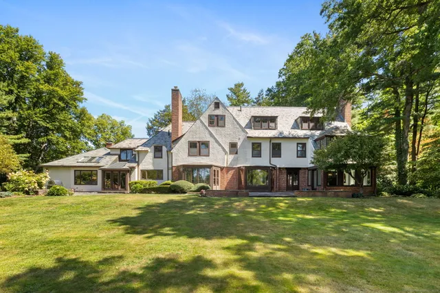 a view of a house with a big yard and large trees