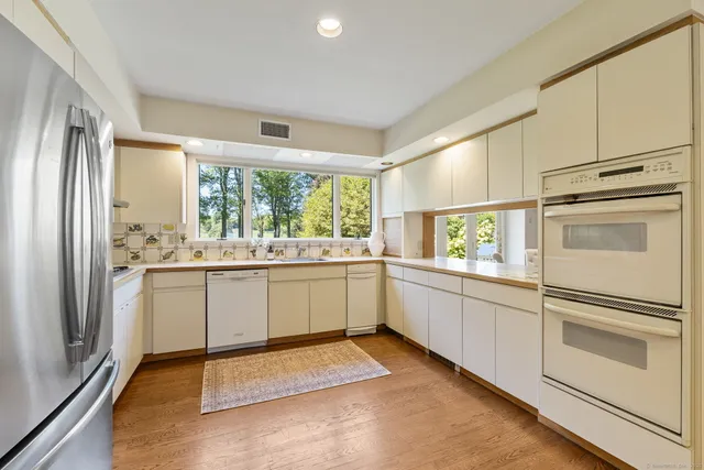 a kitchen with a refrigerator and white cabinets