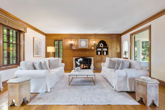 a living room with furniture a large window and a fireplace