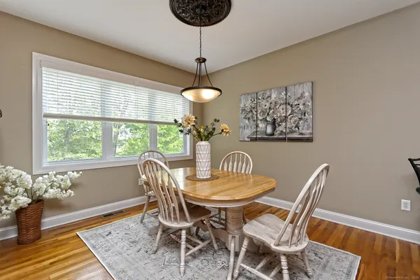 a large kitchen with granite countertop a sink dishwasher a stove and a refrigerator with wooden floor