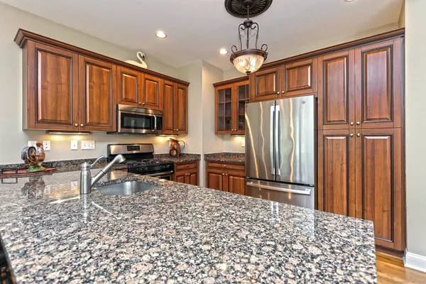 a kitchen with stainless steel appliances granite countertop a refrigerator and a stove top oven