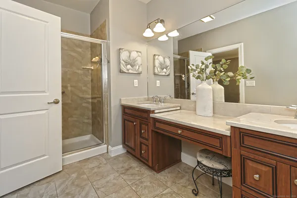a bathroom with a granite countertop sink a mirror and a shower