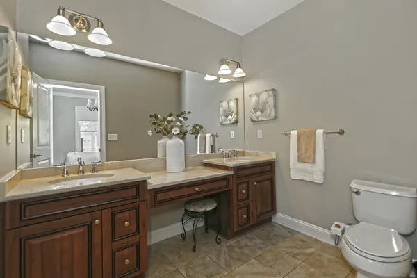a bathroom with a granite countertop sink a toilet and a mirror