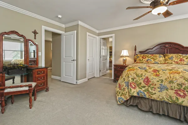 a bedroom with a bed and a mirror on dresser