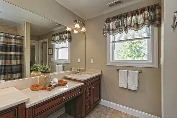 a bathroom with a granite countertop sink a large mirror and a window