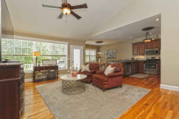a living room with furniture kitchen view and large windows