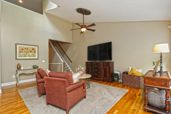 a kitchen with stainless steel appliances granite countertop a refrigerator a sink dishwasher a stove and a dining table with wooden floor