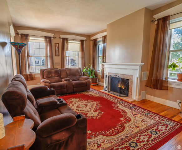 155 West Center Street Fillmore, UT 84631 - Photo 13 of 86 Hardwood flooring throughout the room, complemented by a white fireplace mantel and a tiled firebox