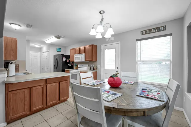 a kitchen with granite countertop a sink dining table and chairs