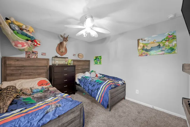 a bedroom with a bed a dresser and decor