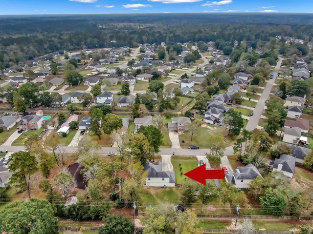 an aerial view of residential houses with outdoor space and trees