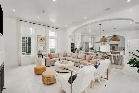a living room with furniture kitchen and a large window